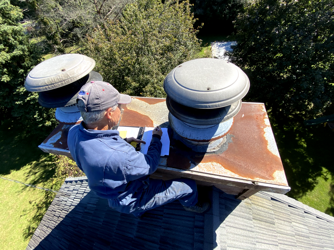 Chimney cap Inspection with rusty old chimney cap